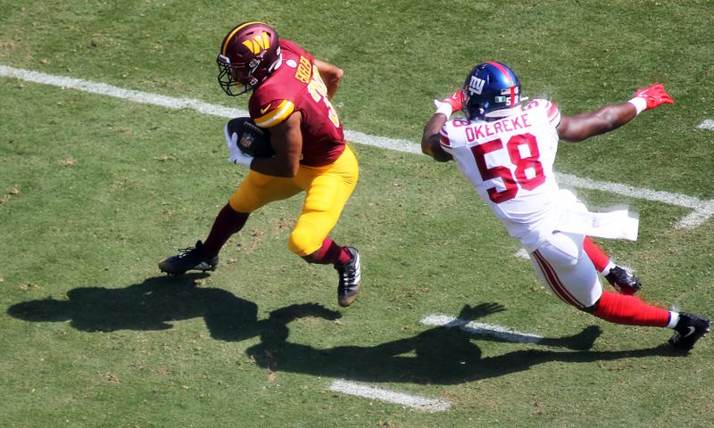 Washington Commanders running back Austin Ekeler (30) runs by New York Giants linebacker Bobby Okereke (58)during an NFL football game, Sunday, September 15, 2024 in Landover. (AP Photo/Daniel Kucin Jr.)