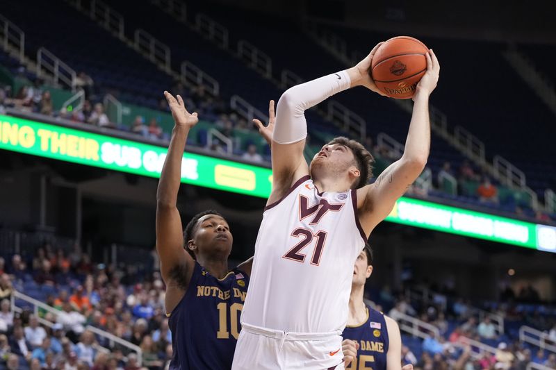 Mar 7, 2023; Greensboro, NC, USA; Virginia Tech Hokies forward Grant Basile (21) shoots as Notre Dame Fighting Irish guard Marcus Hammond (10) defends in the second half at Greensboro Coliseum. Mandatory Credit: Bob Donnan-USA TODAY Sports