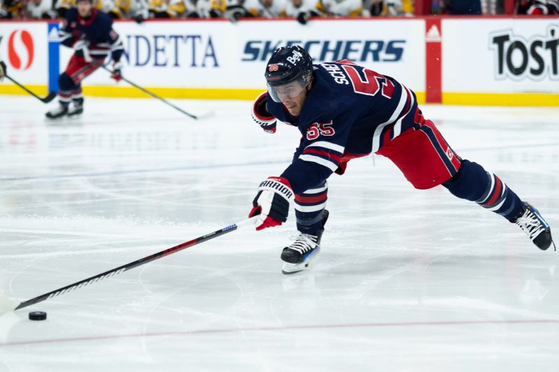 Feb 10, 2024; Winnipeg, Manitoba, CAN;  Winnipeg Jets forward Mark Scheifele (55) reaches for the puck against the Pittsburgh Penguins during the second period at Canada Life Centre. Mandatory Credit: Terrence Lee-USA TODAY Sports