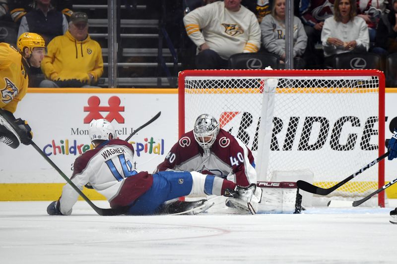 Mar 2, 2024; Nashville, Tennessee, USA; Colorado Avalanche goaltender Alexandar Georgiev (40) makes a save as right wing Chris Wagner (14) falls in the crease during the second period against the Nashville Predators at Bridgestone Arena. Mandatory Credit: Christopher Hanewinckel-USA TODAY Sports