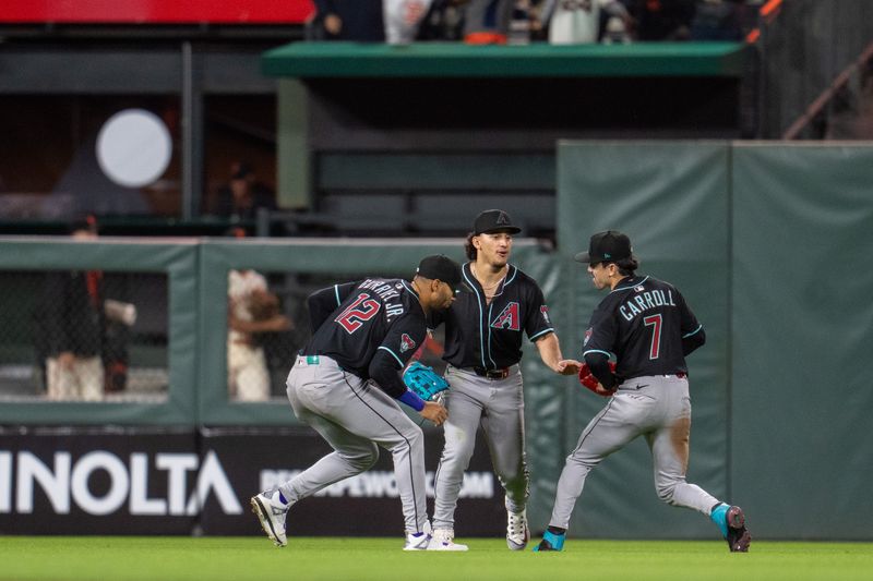 May 12, 2025; San Francisco, California, USA; Arizona Diamondbacks left fielder Lourdes Gurriel Jr. (12) and Arizona Diamondbacks right fielder Corbin Carroll (7) and Arizona Diamondbacks center fielder Alek Thomas (5) celebrate after the game against the San Francisco Giants at Oracle Park. Mandatory Credit: Neville E. Guard-Imagn Images