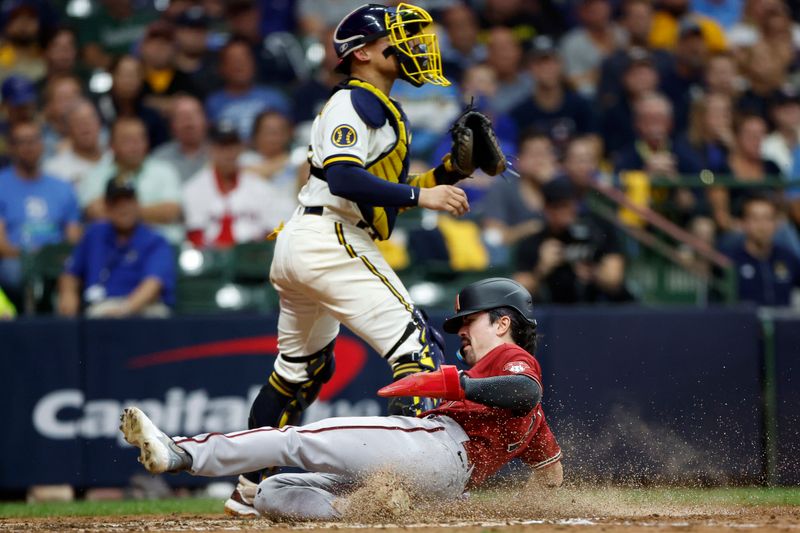 Oct 4, 2023; Milwaukee, Wisconsin, USA; Arizona Diamondbacks left fielder Corbin Carroll (7) slides home to score in the sixth inning against Milwaukee Brewers catcher William Contreras (24) during game two of the Wildcard series for the 2023 MLB playoffs at American Family Field. Mandatory Credit: Kamil Krzaczynski-USA TODAY Sports