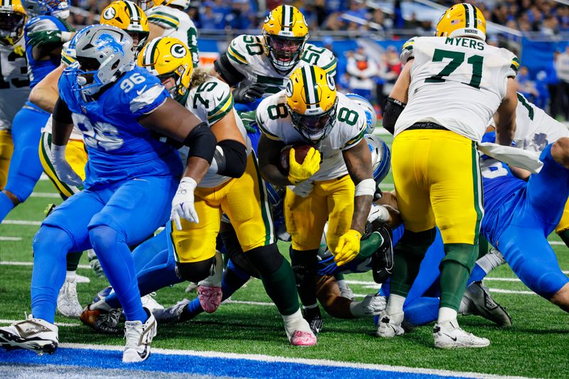 Green Bay Packers running back Josh Jacobs (8) runs in for a touchdown against the Detroit Lions during the second half of an NFL football game in Detroit, Thursday, Dec. 5, 2024. (AP Photo/Duane Burleson)