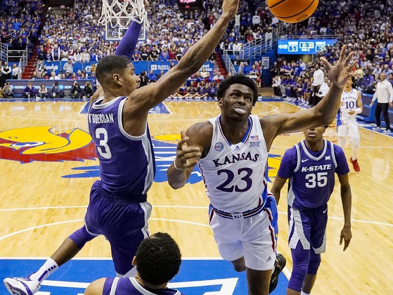 Jan 31, 2023; Lawrence, Kansas, USA; Kansas Jayhawks center Ernest Udeh Jr. (23) loses control of the ball while shooting against Kansas State Wildcats forward David N'Guessan (3) and guard Markquis Nowell (1) during the second half at Allen Fieldhouse. Mandatory Credit: Jay Biggerstaff-USA TODAY Sports