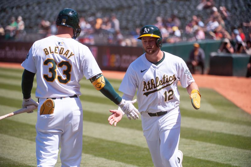 May 7, 2024; Oakland, California, USA; Oakland Athletics outfielder JJ Bleday (33) congratulates second base Max Schuemann (12) after he scored against the Texas Rangers during the sixth inning at Oakland-Alameda County Coliseum. Mandatory Credit: Ed Szczepanski-USA TODAY Sports