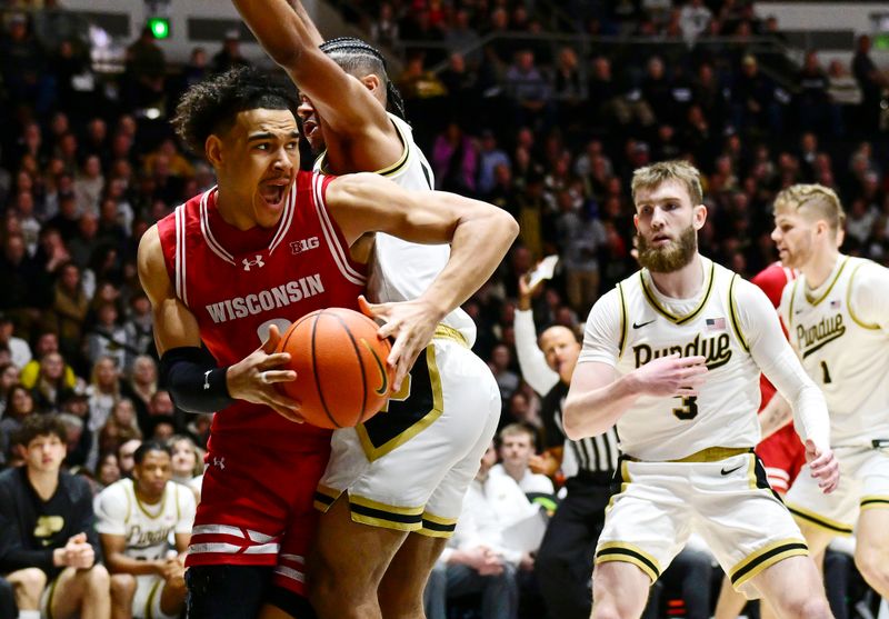 Feb 15, 2025; West Lafayette, Indiana, USA; Wisconsin Badgers guard John Tonje (9) leans to get around Purdue Boilermakers guard C.J. Cox (0) during the first half at Mackey Arena. Mandatory Credit: Marc Lebryk-Imagn Images
