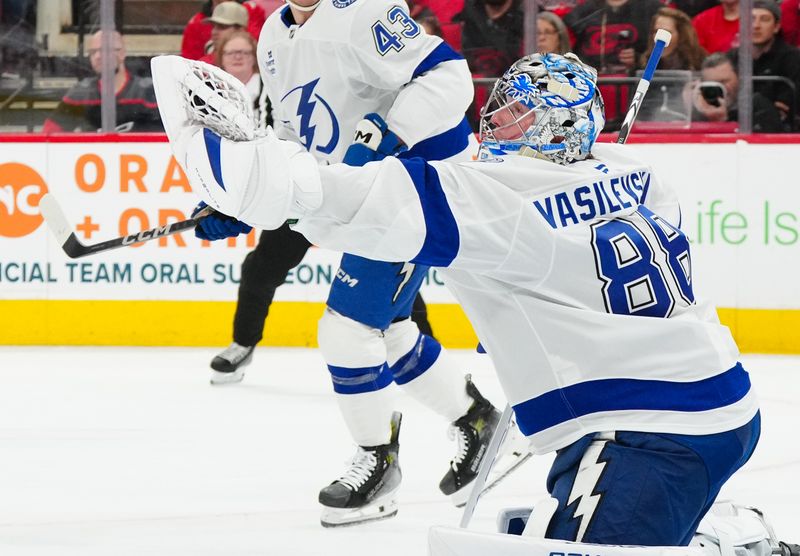 Oct 11, 2024; Raleigh, North Carolina, USA;  aTampa Bay Lightning goaltender Andrei Vasilevskiy (88) makes a glove save against the Carolina Hurricanes during the first period t PNC Arena. Mandatory Credit: James Guillory-Imagn Images