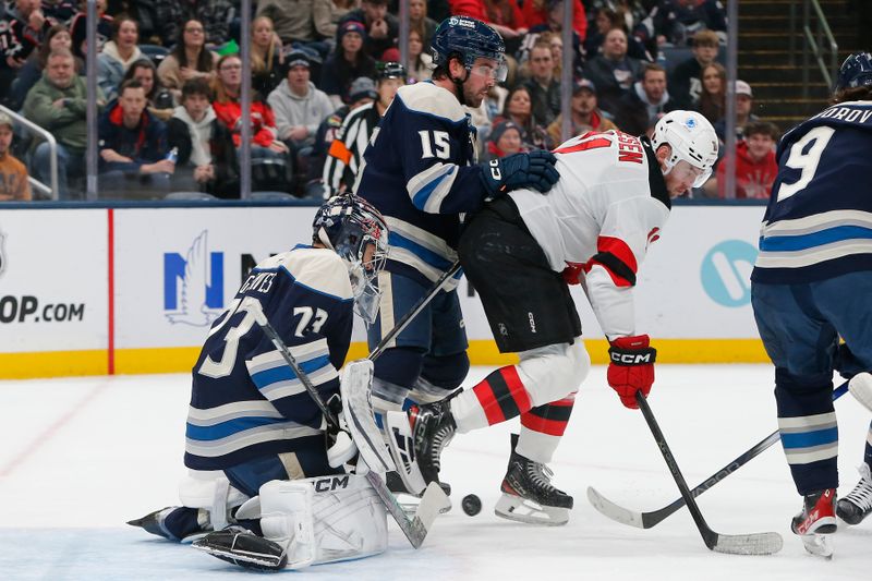 Dec 31, 2025; Columbus, Ohio, USA; Columbus Blue Jackets goalie Jet Greaves (73) makes a stick save as New Jersey Devils left wing Stefan Noesen (11) looks for a rebound during the first period at Nationwide Arena. Mandatory Credit: Russell LaBounty-Imagn Images