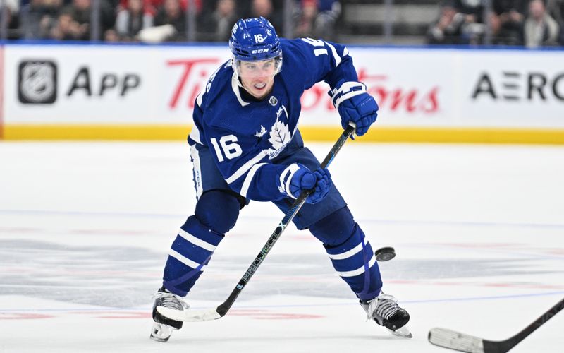 Apr 11, 2024; Toronto, Ontario, CAN; Toronto Maple Leafs forward Mitchell Marner (16) plays the puck against the New Jersey Devils in the third period at Scotiabank Arena. Mandatory Credit: Dan Hamilton-USA TODAY Sports