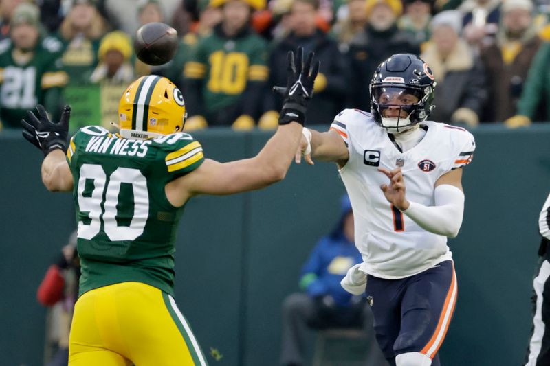 Chicago Bears quarterback Justin Fields (1) throws past Green Bay Packers linebacker Lukas Van Ness (90) during the first half of an NFL football game Sunday, Jan. 7, 2024, in Green Bay, Wis. (AP Photo/Mike Roemer)