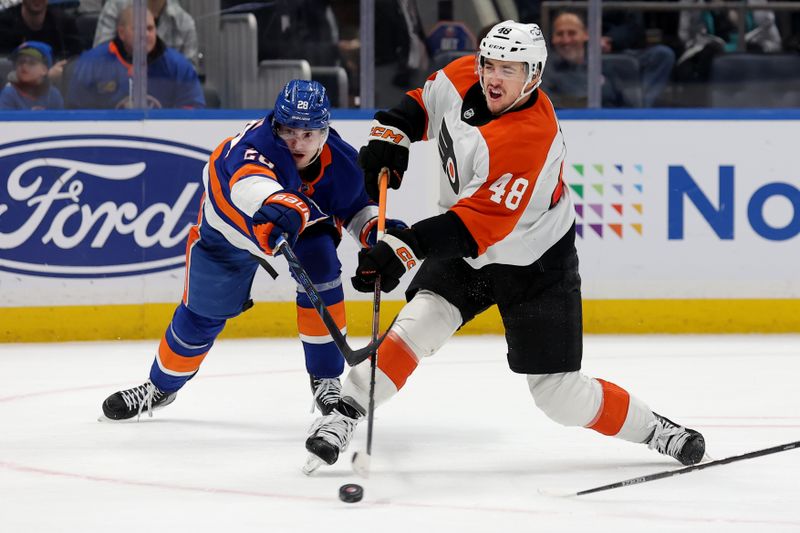 Jan 24, 2025; Elmont, New York, USA; Philadelphia Flyers center Morgan Frost (48) takes a shot against New York Islanders defenseman Alexander Romanov (28) during the first period at UBS Arena. Mandatory Credit: Brad Penner-Imagn Images