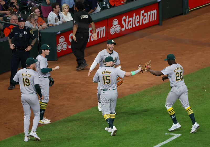 Sep 10, 2024; Houston, Texas, USA; Oakland Athletics right fielder Seth Brown (15) and teammates celebrate  right fielder Daz Cameron (28) game saving catch against the Houston Astros in the 10th inning  at Minute Maid Park. Mandatory Credit: Thomas Shea-Imagn Images