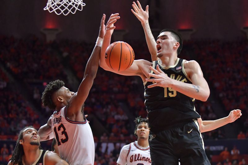 Mar 5, 2024; Champaign, Illinois, USA; Illinois Fighting Illini forward Quincy Guerrier (13) knocks the ball from Purdue Boilermakers center Zach Edey (15) during the second half at State Farm Center. Mandatory Credit: Ron Johnson-USA TODAY Sports