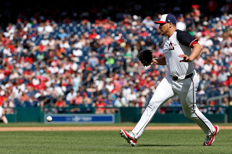 Jun 9, 2024; Washington, District of Columbia, USA; Washington Nationals relief pitcher Robert Garcia (61) attempts to field a ground ball by Atlanta Braves shortstop Orlando Arcia (11) during the sixth inning at Nationals Park. Mandatory Credit: Geoff Burke-USA TODAY Sports