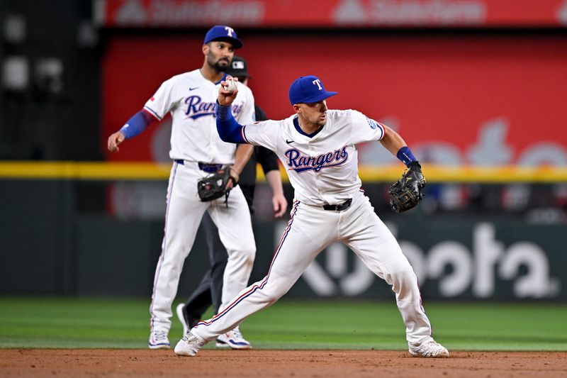 May 1, 2025; Arlington, Texas, USA; Texas Rangers second baseman Marcus Semien (2) looks on as shortstop Nick Ahmed (23) throws out Athletics designated hitter Brent Rooker (not pictured) during the third inning at Globe Life Field. Mandatory Credit: Jerome Miron-Imagn Images