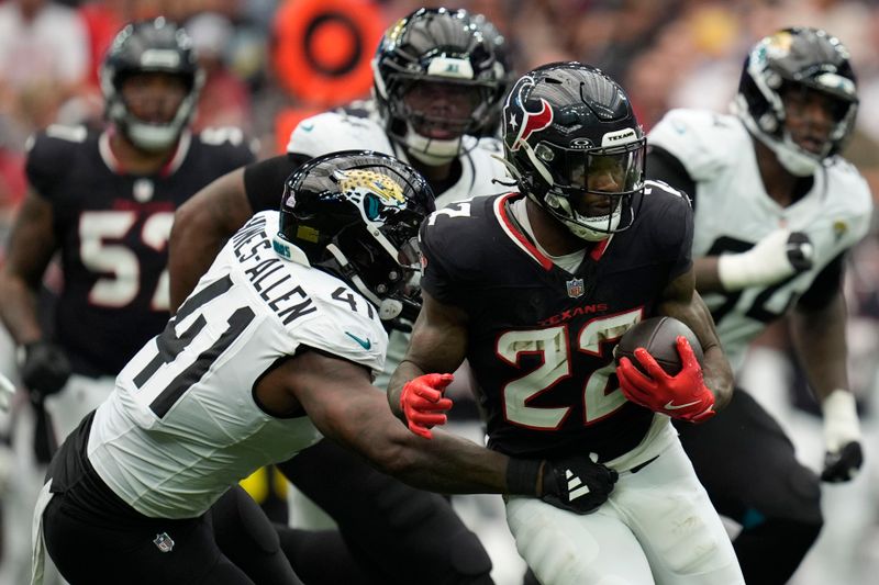 Houston Texans running back Cam Akers (22) runs from Jacksonville Jaguars defensive end Josh Hines-Allen (41) during the first half of an NFL football game, Sunday, Sept. 29, 2024, in Houston. (AP Photo/Eric Gay)