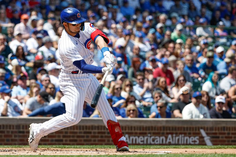 May 5, 2023; Chicago, Illinois, USA; Chicago Cubs right fielder Seiya Suzuki (27) hits an RBI-single against the Miami Marlins during the first inning at Wrigley Field. Mandatory Credit: Kamil Krzaczynski-USA TODAY Sports