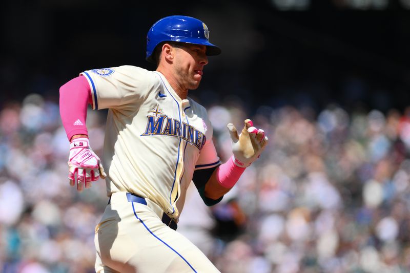 May 12, 2024; Seattle, Washington, USA; Seattle Mariners shortstop Dylan Moore (25) runs towards first base after hitting a single against the Oakland Athletics during the first inning at T-Mobile Park. Mandatory Credit: Steven Bisig-USA TODAY Sports