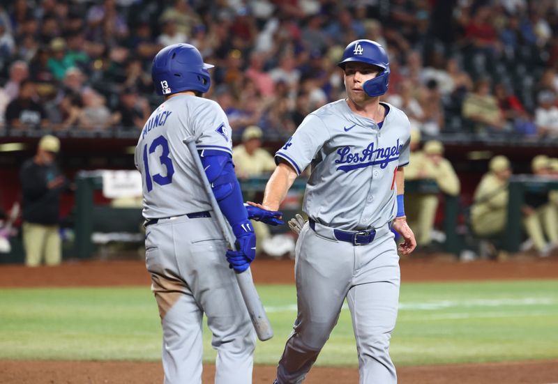 Apr 30, 2024; Phoenix, Arizona, USA; Los Angeles Dodgers Catcher Will Smith (right) celebrates with teammate Max Muncy after scoring on a balk in the sixth inning against the Arizona Diamondbacks at Chase Field. Mandatory Credit: Mark J. Rebilas-USA TODAY Sports