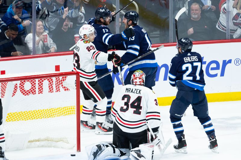 Jan 11, 2024; Winnipeg, Manitoba, CAN; Winnipeg Jets forward Gabriel Vilardi (13) is congratulated by Winnipeg Jets forward Adam Lowry (17) on his goal against Chicago Blackhawks goalie Petr Mrazek (34) during the third period at Canada Life Centre. Mandatory Credit: Terrence Lee-USA TODAY Sports