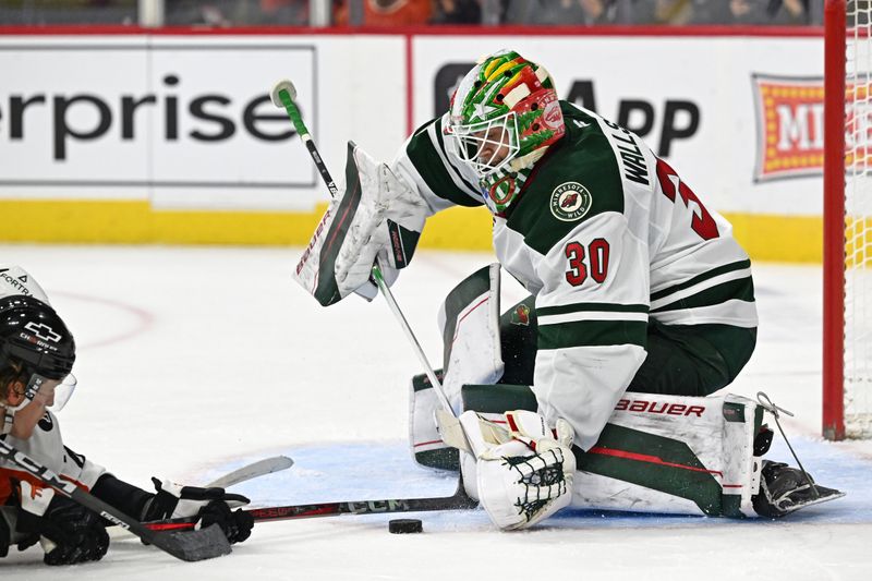 Oct 18, 2025; Philadelphia, Pennsylvania, USA; Minnesota Wild goaltender Jesper Wallstedt (30) covers the puck against the Philadelphia Flyers during the first period at Wells Fargo Center. Mandatory Credit: Eric Hartline-Imagn Images