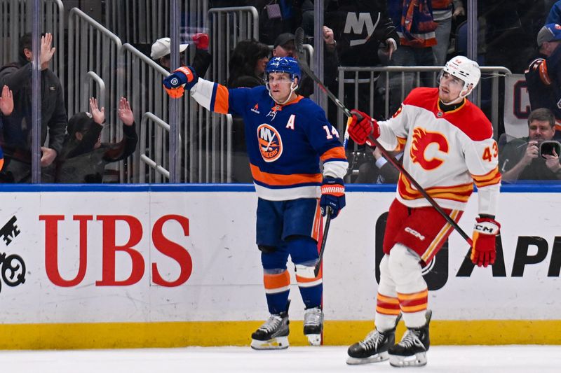 Mar 22, 2025; Elmont, New York, USA;  New York Islanders center Bo Horvat (14) celebrates his goal against the Calgary Flames during the first period at UBS Arena. Mandatory Credit: Dennis Schneidler-Imagn Images