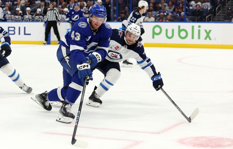 wNov 14, 2024; Tampa, Florida, USA; Winnipeg Jets  defenseman Neal Pionk (4) defends Tampa Bay Lightning defenseman Darren Raddysh (43) during the third period at Amalie Arena. Mandatory Credit: Kim Klement Neitzel-Imagn Images