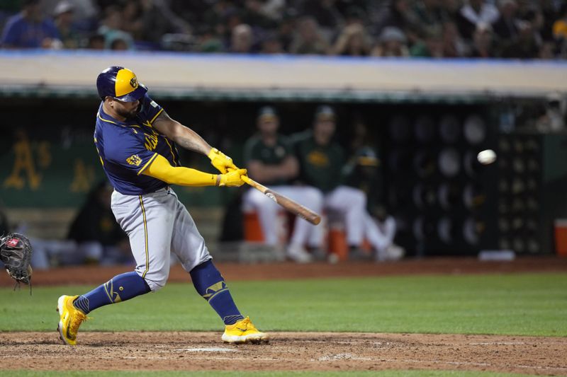 Aug 23, 2024; Oakland, California, USA; Milwaukee Brewers designated hitter Gary Sanchez (99) hits an RBI triple against the Oakland Athletics during the ninth inning at Oakland-Alameda County Coliseum. Mandatory Credit: Darren Yamashita-USA TODAY Sports