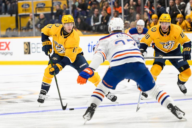 Oct 17, 2024; Nashville, Tennessee, USA;  Nashville Predators center Mark Jankowski (17) skates as Edmonton Oilers defenseman Brett Kulak (27) defends during the third period at Bridgestone Arena. Mandatory Credit: Steve Roberts-Imagn Images