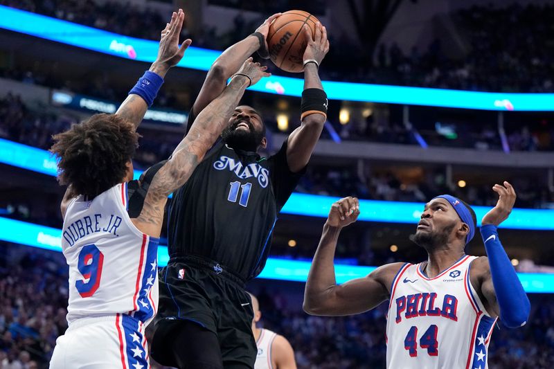 DALLAS, TEXAS - MARCH 03: Kyrie Irving #11 of the Dallas Mavericks is defended by Kelly Oubre Jr. #9 and Paul Reed #44 of the Philadelphia 76ers during the second half at American Airlines Center on March 03, 2024 in Dallas, Texas. NOTE TO USER: User expressly acknowledges and agrees that, by downloading and or using this photograph, User is consenting to the terms and conditions of the Getty Images License Agreement. (Photo by Sam Hodde/Getty Images)