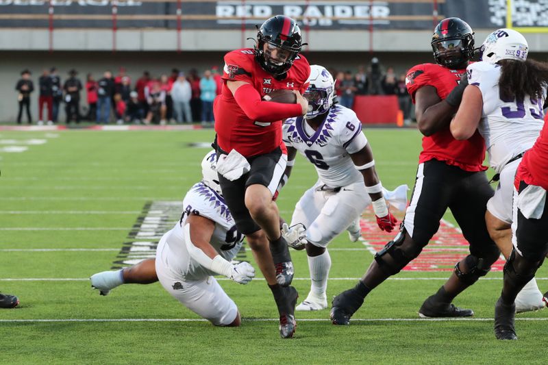 Nov 2, 2023; Lubbock, Texas, USA; Texas Tech Red Raiders quarterback Behren Morton (2) breaks a tackle by Texas Christian Horned Frogs defensive end Caleb Fox (90) in the first half at Jones AT&T Stadium and Cody Campbell Field. Mandatory Credit: Michael C. Johnson-USA TODAY Sports