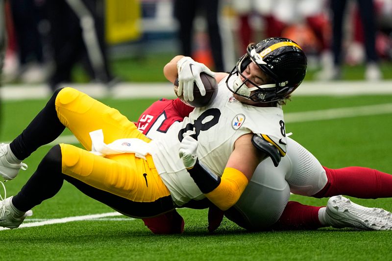 Pittsburgh Steelers quarterback Kenny Pickett (8) is sacked by Houston Texans defensive end Jerry Hughes (55) during the first half of an NFL football game Sunday, Oct. 1, 2023, in Houston. (AP Photo/David J. Phillip)