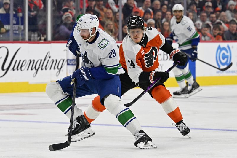 Dec 22, 2025; Philadelphia, Pennsylvania, USA; Vancouver Canucks defenseman Marcus Pettersson (29) controls the puck against Philadelphia Flyers right wing Owen Tippett (74) during the second period at Xfinity Mobile Arena. Mandatory Credit: Eric Hartline-Imagn Images