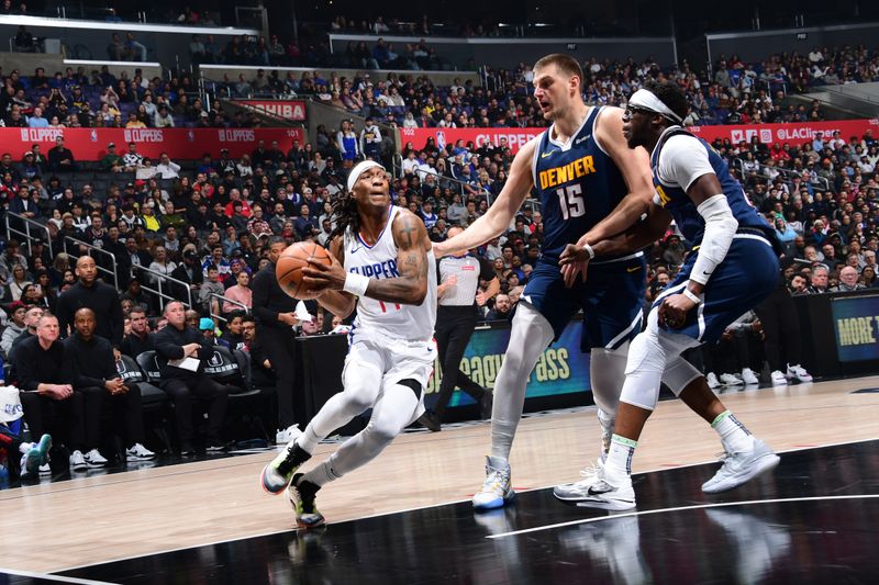 LOS ANGELES, CA - APRIL 4: Terance Mann #14 of the LA Clippers drives to the basket during the game against the Denver Nuggets on April 4, 2024 at Crypto.Com Arena in Los Angeles, California. NOTE TO USER: User expressly acknowledges and agrees that, by downloading and/or using this Photograph, user is consenting to the terms and conditions of the Getty Images License Agreement. Mandatory Copyright Notice: Copyright 2024 NBAE (Photo by Adam Pantozzi/NBAE via Getty Images)