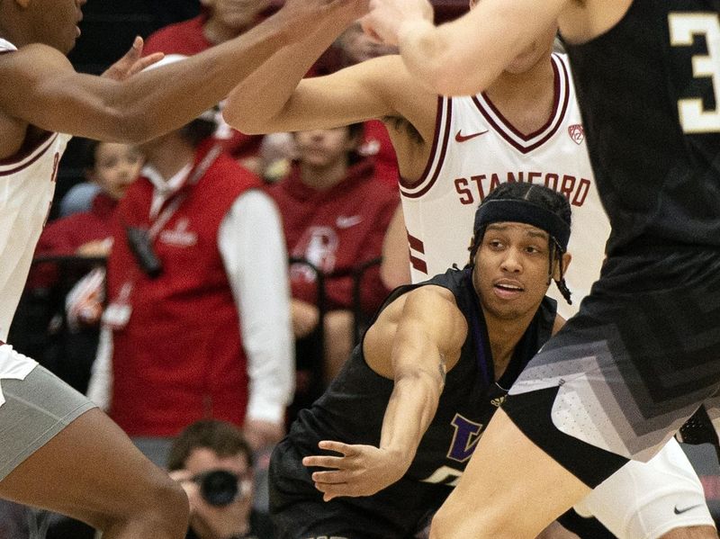 Feb 26, 2023; Stanford, California, USA; Washington Huskies guard Koren Johnson (0) passes the ball through a trio of Stanford Cardinal defenders during the first half at Maples Pavilion. Mandatory Credit: D. Ross Cameron-USA TODAY Sports