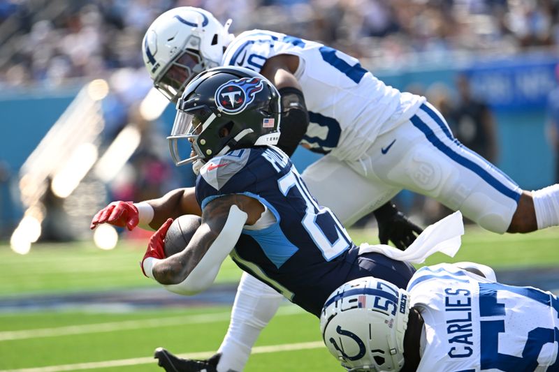 Tennessee Titans running back Tony Pollard (20) is tackled byIndianapolis Colts' Jaylon Carlies (57) during the first half of an NFL football game, Sunday, Oct. 13, 2024, in Nashville, Tenn. (AP Photo/John Amis)