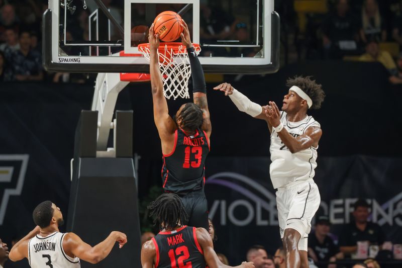 Jan 25, 2023; Orlando, Florida, USA; Houston Cougars forward J'Wan Roberts (13) dunks the ball in front of UCF Knights forward Taylor Hendricks (25) during the first half at Addition Financial Arena. Mandatory Credit: Mike Watters-USA TODAY Sports