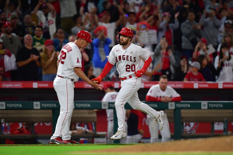 Sep 15, 2023; Anaheim, California, USA;  Los Angeles Angels first baseman Jared Walsh (20) is greeted by third base coach Bill Haselman (82) after hitting a solo home run against the Detroit Tigers during the ninth inning at Angel Stadium. Mandatory Credit: Gary A. Vasquez-USA TODAY Sports