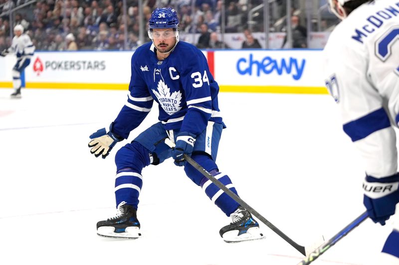 Oct 21, 2024; Toronto, Ontario, CAN; Toronto Maple Leafs forward Auston Matthews (34) defends a pass by Tampa Bay Lightning defenseman Ryan McDonagh (27)  during the first period at Scotiabank Arena. Mandatory Credit: John E. Sokolowski-Imagn Images