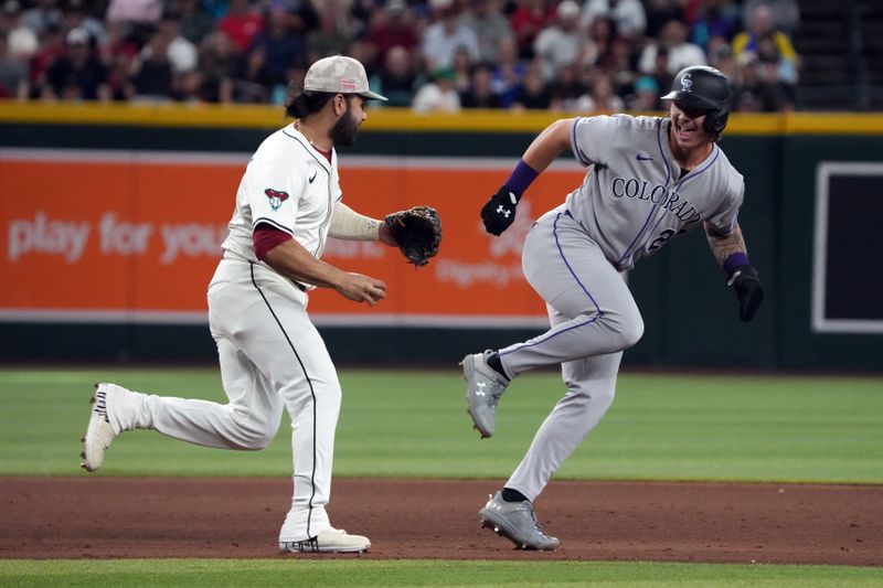 May 18, 2025; Phoenix, Arizona, USA; Arizona Diamondbacks third base Eugenio Suarez (28) tags out Colorado Rockies outfielder Jordan Beck (27) during a run down in the sixth inning at Chase Field. Mandatory Credit: Rick Scuteri-Imagn Images