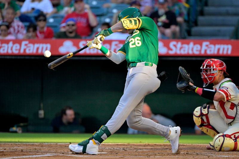 Jun 24, 2024; Anaheim, California, USA;  Oakland Athletics right fielder Tyler Nevin (26) hits a solo home run in the second inning against the Los Angeles Angels at Angel Stadium. Mandatory Credit: Jayne Kamin-Oncea-USA TODAY Sports
