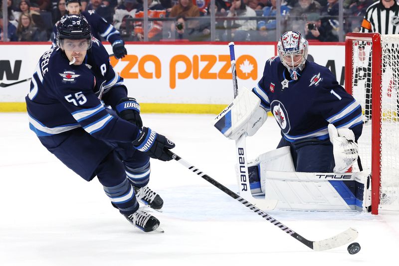 Apr 13, 2025; Winnipeg, Manitoba, CAN; Winnipeg Jets center Mark Scheifele (55) picks up a rebound in a game against the Edmonton Oilers in front of Winnipeg Jets goaltender Winnipeg Jets goaltender Eric Comrie (1) during the first period at Canada Life Centre. Mandatory Credit: James Carey Lauder-Imagn Images