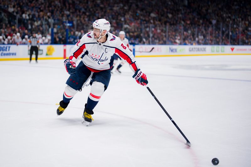 Mar 16, 2024; Vancouver, British Columbia, CAN; Washington Capitals forward Alex Ovechkin (8) reaches for the loose puck against the Vancouver Canucks in the second period at Rogers Arena. Mandatory Credit: Bob Frid-USA TODAY Sports