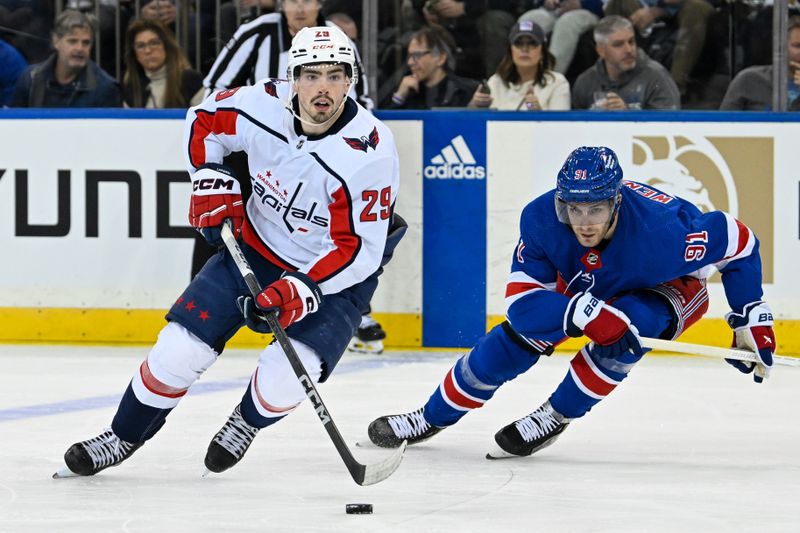 Apr 23, 2024; New York, New York, USA; Washington Capitals center Hendrix Lapierre (29) skates with the puck chased by New York Rangers center Alex Wennberg (91) during the second period in game two of the first round of the 2024 Stanley Cup Playoffs at Madison Square Garden. Mandatory Credit: Dennis Schneidler-USA TODAY Sports