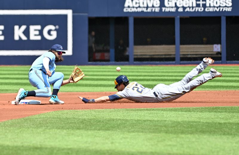 Jun 1, 2023; Toronto, Ontario, CAN;  Milwaukee Brewers designated hitter Christian Yelich (22) is tagged out by Toronto Blue Jays shortstop Bo Bichette (11) trying to steal second base in the first inning at Rogers Centre. Mandatory Credit: Dan Hamilton-USA TODAY Sports