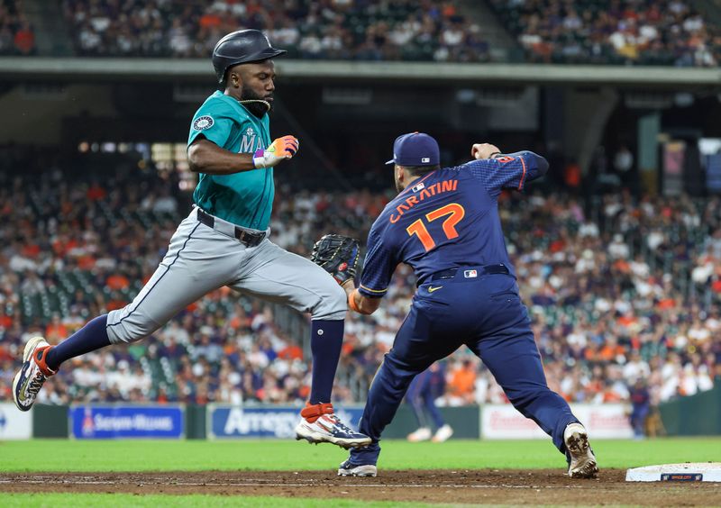 Sep 23, 2024; Houston, Texas, USA; Seattle Mariners left fielder Randy Arozarena (56) is safe at first base as Houston Astros first baseman Victor Caratini (17) waits for the throw during the eighth inning at Minute Maid Park. Mandatory Credit: Troy Taormina-Imagn Images