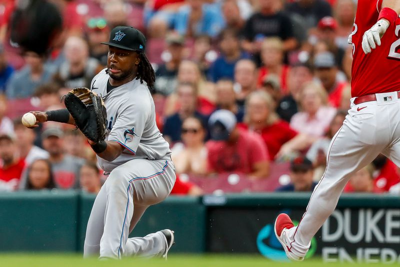 Aug 8, 2023; Cincinnati, Ohio, USA; Miami Marlins first baseman Josh Bell (9) catches a pass and tags Cincinnati Reds catcher Luke Maile (22) out in the fifth inning at Great American Ball Park. Mandatory Credit: Katie Stratman-USA TODAY Sports