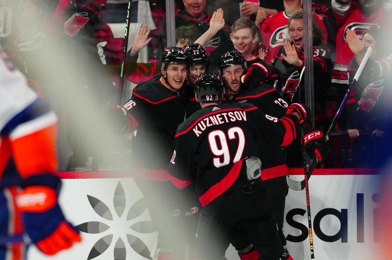 Apr 20, 2024; Raleigh, North Carolina, USA; Carolina Hurricanes right wing Stefan Noesen (23) celebrates his goal with with defenseman Brett Pesce (22) defenseman Brady Skjei (76) and center Evgeny Kuznetsov (92) during the third period against the New York Islanders in game one of the first round of the 2024 Stanley Cup Playoffs at PNC Arena. Mandatory Credit: James Guillory-USA TODAY Sports