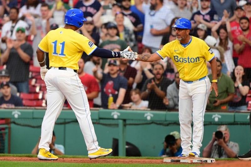 May 3, 2025; Boston, Massachusetts, USA; Boston Red Sox designated hitter Rafael Devers (11) is congratulated by first base coach/infield instructor José David Flores (58) after hitting an RBI single during the seventh inning against the Minnesota Twins at Fenway Park. Mandatory Credit: Bob DeChiara-Imagn Images