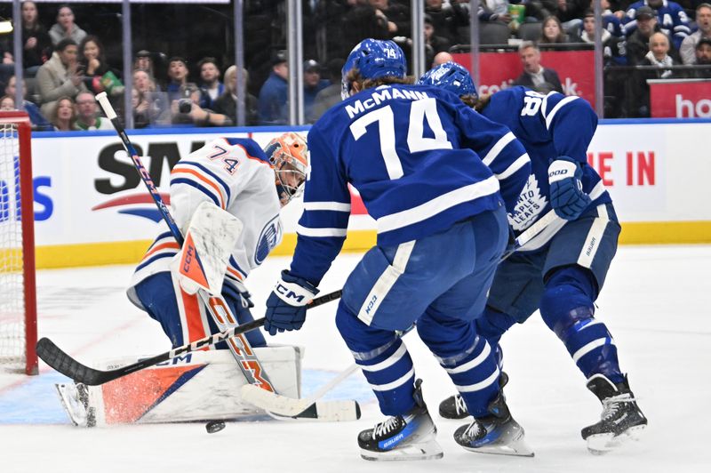 Mar 23, 2024; Toronto, Ontario, CAN;  Edmonton Oilers goalie Stuart Skinner (74) makes a save on Toronto Maple Leafs forward Bobby McMann (74) in the first period at Scotiabank Arena. Mandatory Credit: Dan Hamilton-USA TODAY Sports